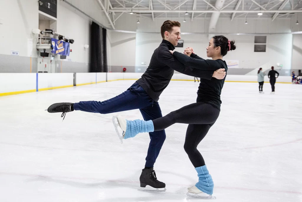 A man and a woman on an ice skating rink.